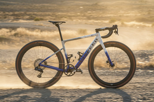 Cyclocross bicycle with blue frame and orange tires on a black background